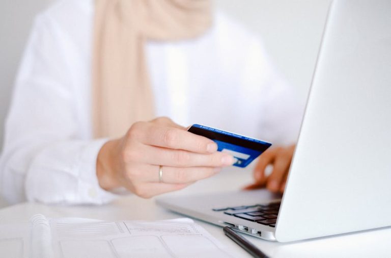 Person using a laptop and card for online banking or payments