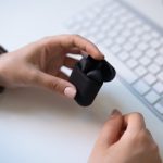 Wireless earbuds near a keyboard on a clean desk