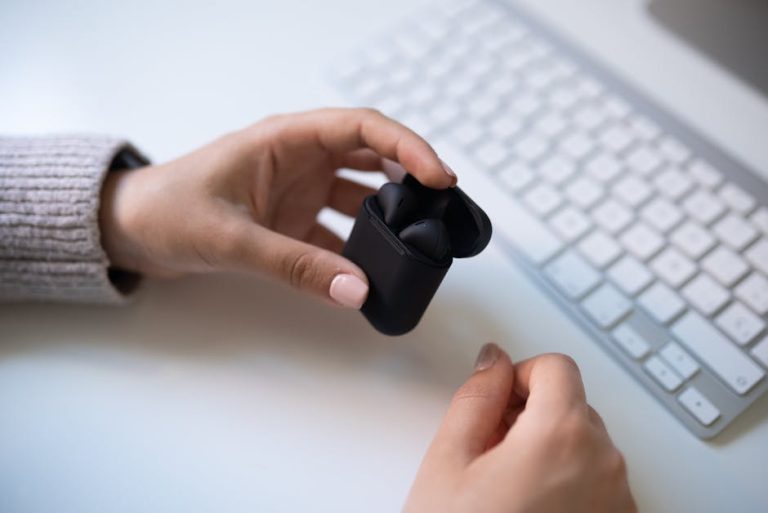 Wireless earbuds near a keyboard on a clean desk