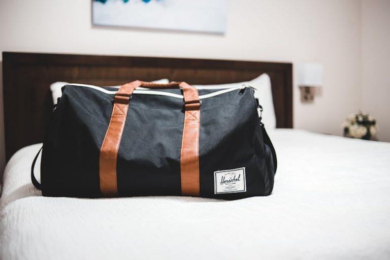 Suitcase beside a hotel bed ready for travel