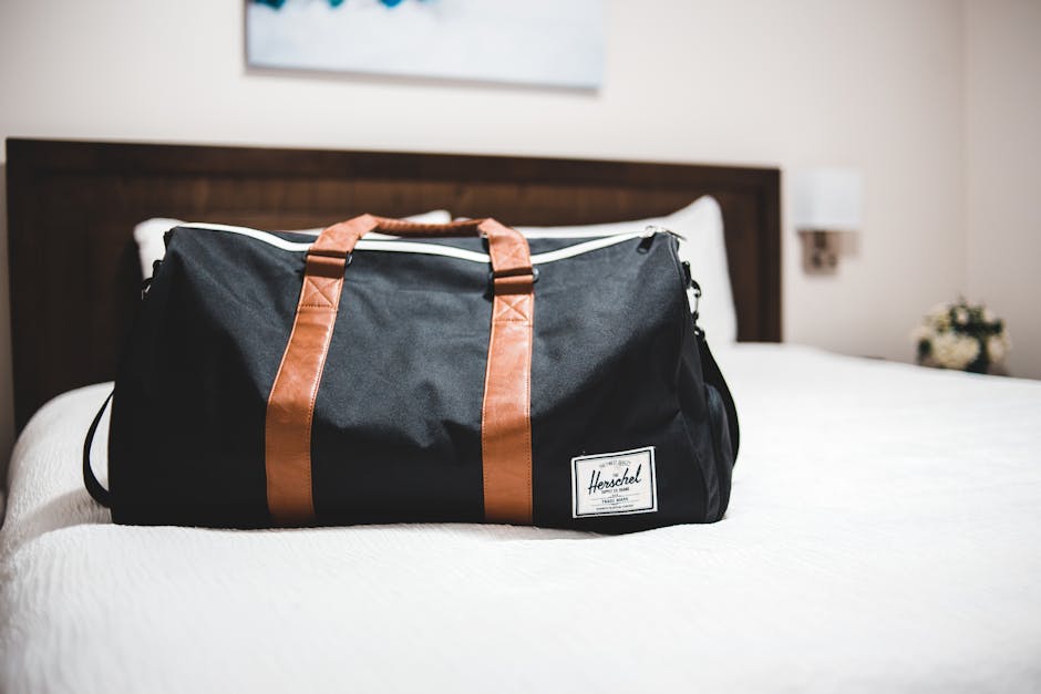 Suitcase beside a hotel bed ready for travel